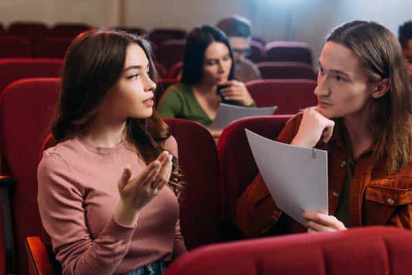 young actors and actresses reading scripts in theatre
